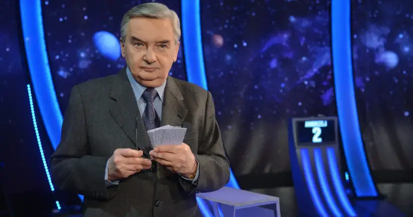 Tadeusz Sznuk, prowadzący Jeden z dziesięciu, trzyma karty z numerami.