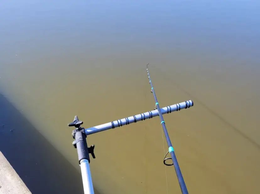 Wędka trzyczęściowa na stojaku nad wodą. Proste wskazówki, jak składać wędkę trzyczęściową, by była gotowa do łowienia.