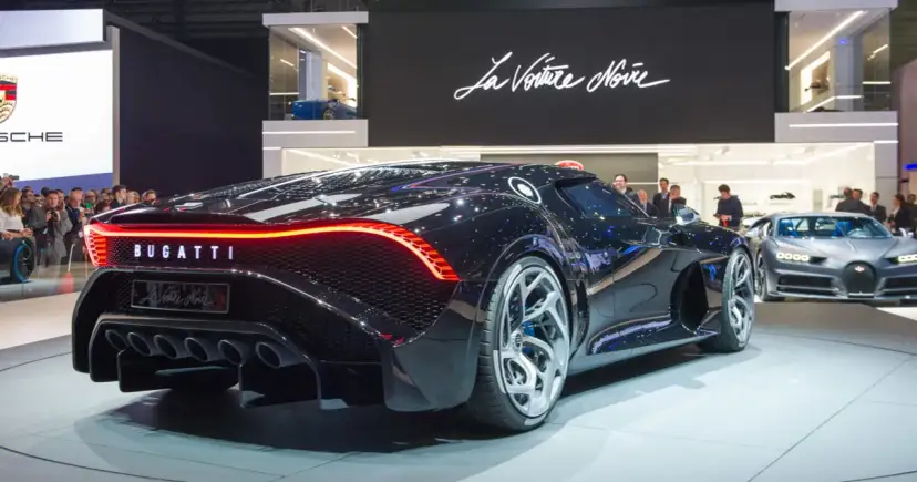 Czarny Bugatti La Voiture Noire z czerwonym pasem świateł z tyłu, na wystawie samochodowej.