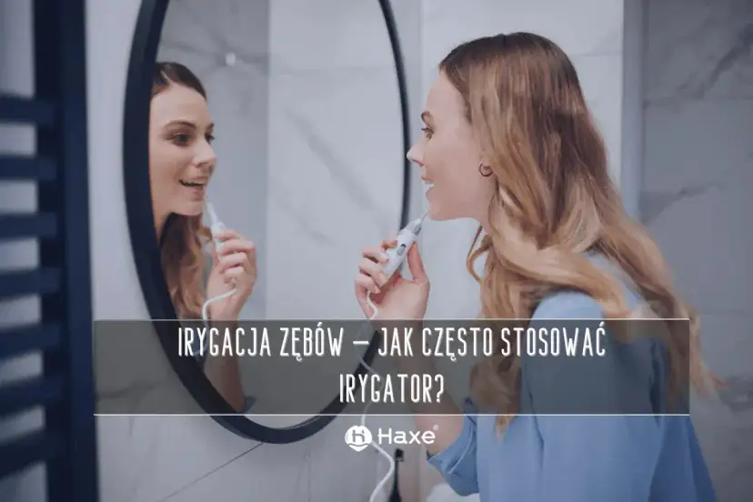 Kobieta używa irygatora do zębów przed lustrem. Dowiedz się, jak często stosować irygator dla zdrowego uśmiechu.
