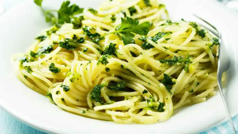 Pyszne spaghetti z zielonym pesto i świeżą natką pietruszki. Idealne na szybki obiad, inspiracja z przepisów z pesto.