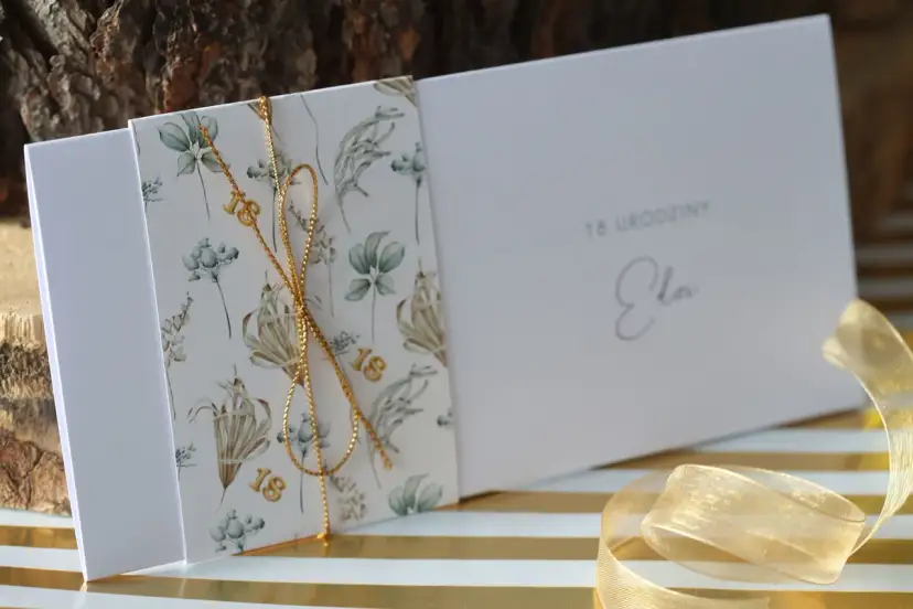 Eleganckie zaproszenia na 18 urodziny z motywem roślinnym i złotym sznurkiem. Idealne, by pokazać, jak spersonalizować zaproszenia na osiemnastkę diy pomysły i materiały.