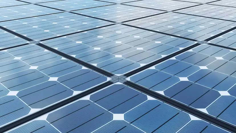 Siatka niebieskich paneli fotowoltaicznych odbija chmury.