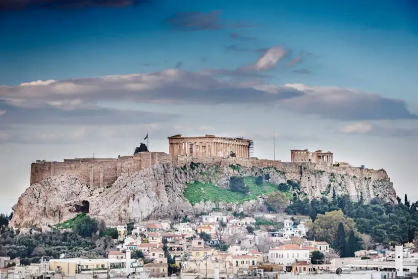 Akropol w Atenach góruje nad miastem. Czy w Atenach jest bezpiecznie? Turyści zwiedzają starożytne ruiny, ciesząc się pięknymi widokami.