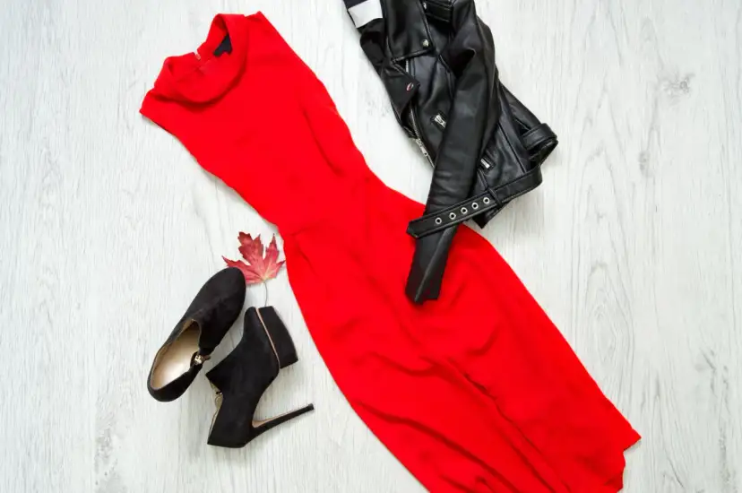 Czerwona sukienka wieczorowa, czarna ramoneska i zamszowe botki. Inspiracja, jak dobrać buty do sukienki wieczorowej, by stworzyć odważny look.