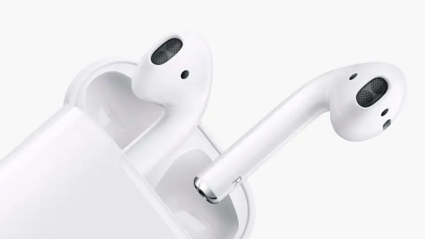 Białe słuchawki AirPods z etui ładującym na białym tle.