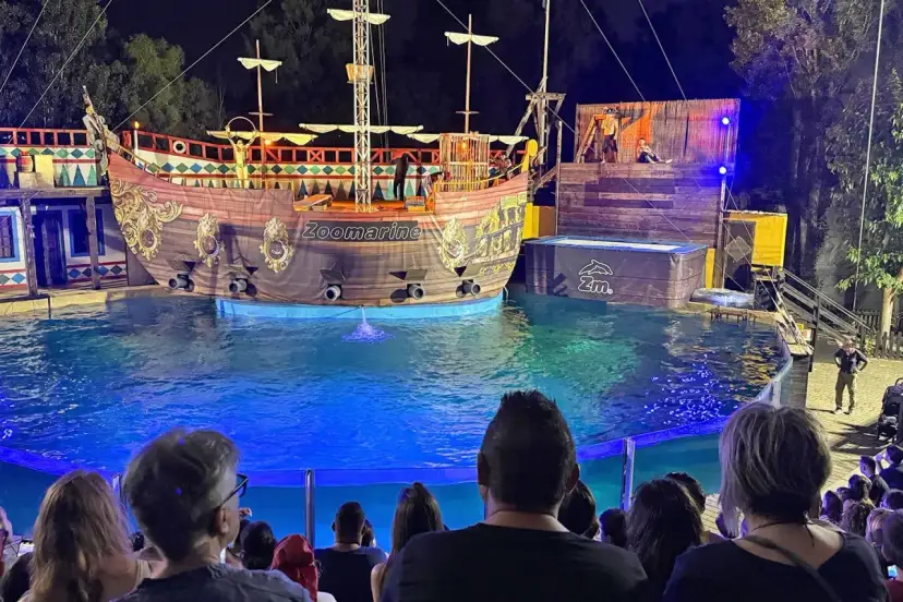 A pirate ship show at Zoomarine Roma with performers on a stage and in the water.