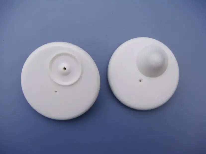 Dwa białe klipsy zabezpieczające z odzieży. Zastanawiasz się, co zrobic jak w ubraniu ze sklepu zostal ci klips? Oto rozwiązanie!