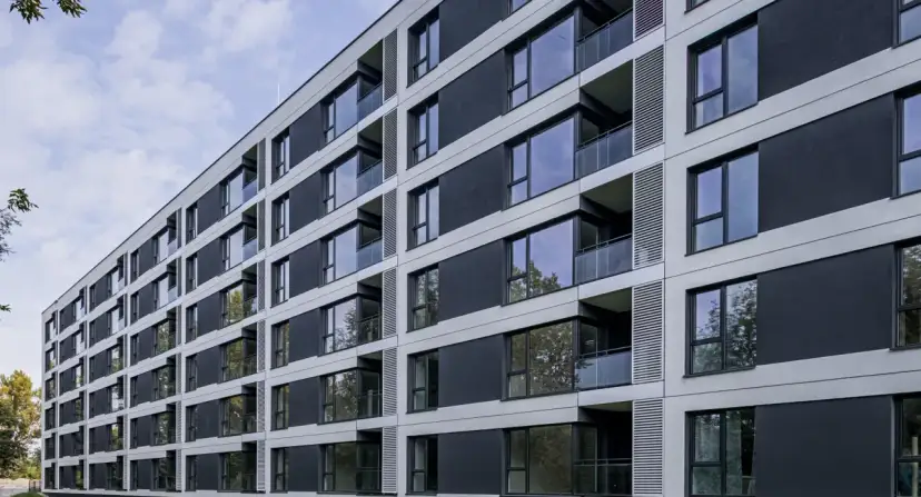 Nowoczesny blok mieszkalny z balkonami i dużymi oknami. Czy mieszkanie komunalne można wynająć w takim miejscu?