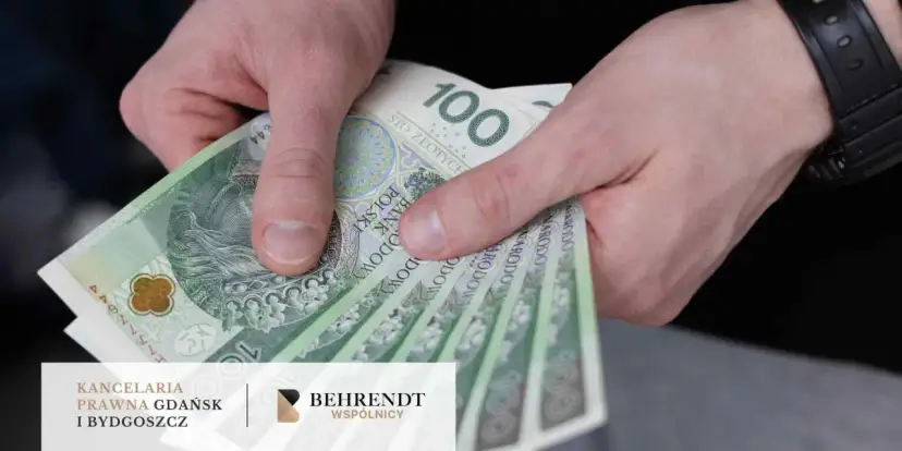 Dłoń trzyma banknoty 100 zł. Jak odzyskać pieniądze z obligacji Getin Bank? Prawnicy pomogą.
