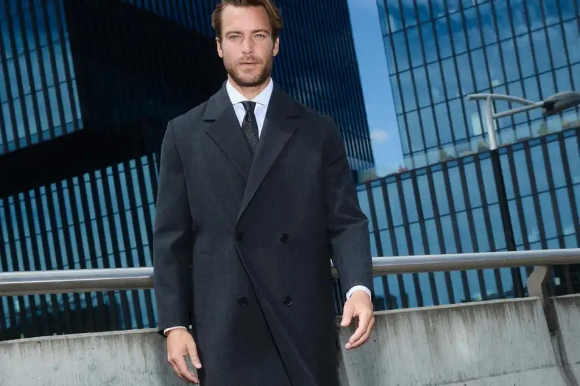 Elegancki mężczyzna w ciemnej, dwurzędowej marynarce i płaszczu, idealna stylizacja: jaka kurtka na marynarkę damska?