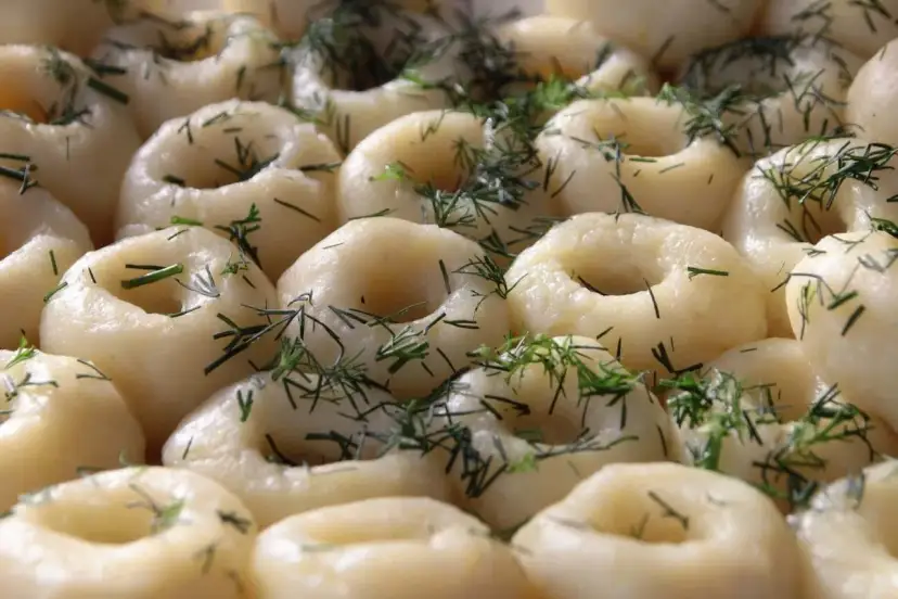 Pyszne kluski śląskie, idealne do sosu, posypane świeżym koperkiem.