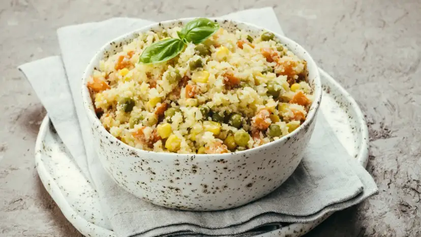 Miseczka ryżu z warzywami, w tym groszkiem. Czy pies może jeść groszek z puszki? Tak, ale w małych ilościach.