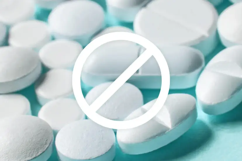 Białe tabletki i znak zakazu. Zrozum, dlaczego lekarze przepisują antybiotyki na wirusy, choć nie powinni.