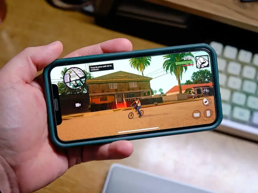 Ręka trzyma smartfon z grą GTA: San Andreas. To świetny przykład darmowe gry na komórkę, które pozwalają na wirtualną rozrywkę.