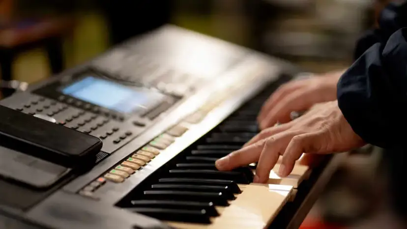 Dłonie grające na keyboardzie, który może być świetnym keyboardem dla dzieci.