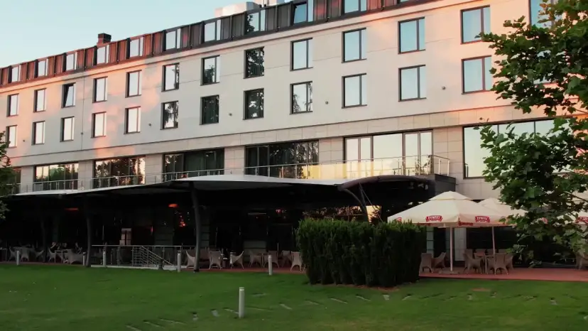 Nowoczesny hotel z tarasem i ogródkiem, gdzie można usiąść. Czy to jeden z hoteli Hilton w Warszawie?