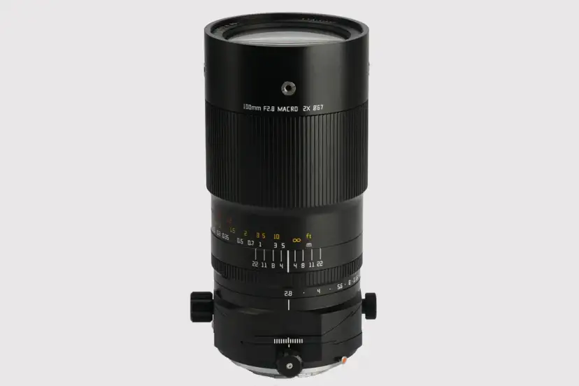 Czarny obiektyw makro 100mm f/2.8 z oznaczeniami odległości i przysłony.