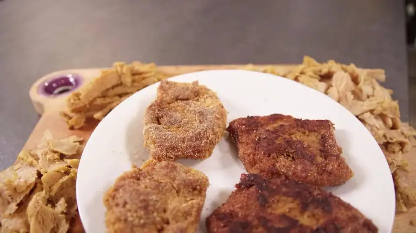 Kotlety sojowe na talerzu i surowe kawałki soi na desce.