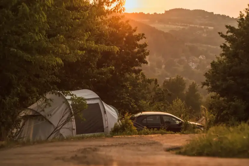 Namiot i samochód na tle malowniczego krajobrazu o zachodzie słońca. Idealne miejsce na **camping Kraków**.