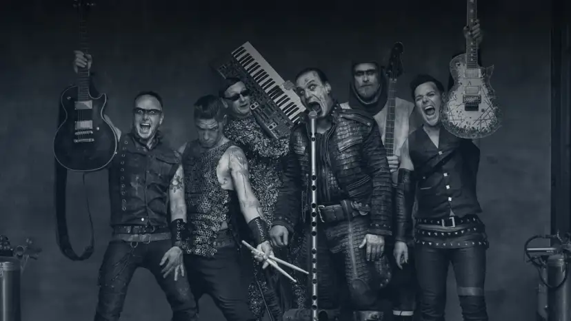 Rammstein-Bandmitglieder mit Instrumenten, schwarz-weiß.