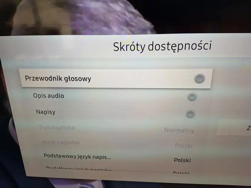 Menu telewizora z opcjami "Przewodnik głosowy", "Opis audio", "Napisy", "Tryb napisów", "Język napisów".