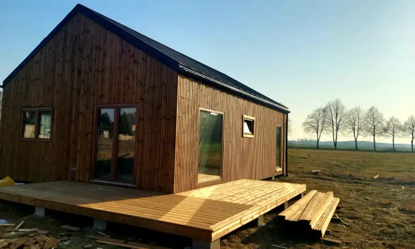 Nowoczesny, drewniany dom z tarasem. Idealny, gdy zastanawiasz się, ile m2 dom bez pozwolenia na budowę możesz postawić.