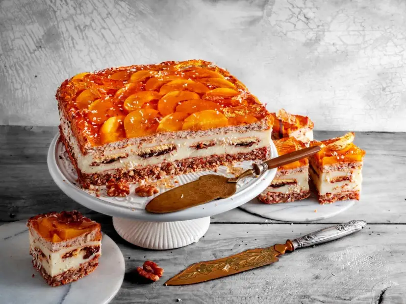 Pyszne ciasto kora dębu z brzoskwiniami i kremem, udekorowane wiórkami kokosowymi. Idealne na deser.