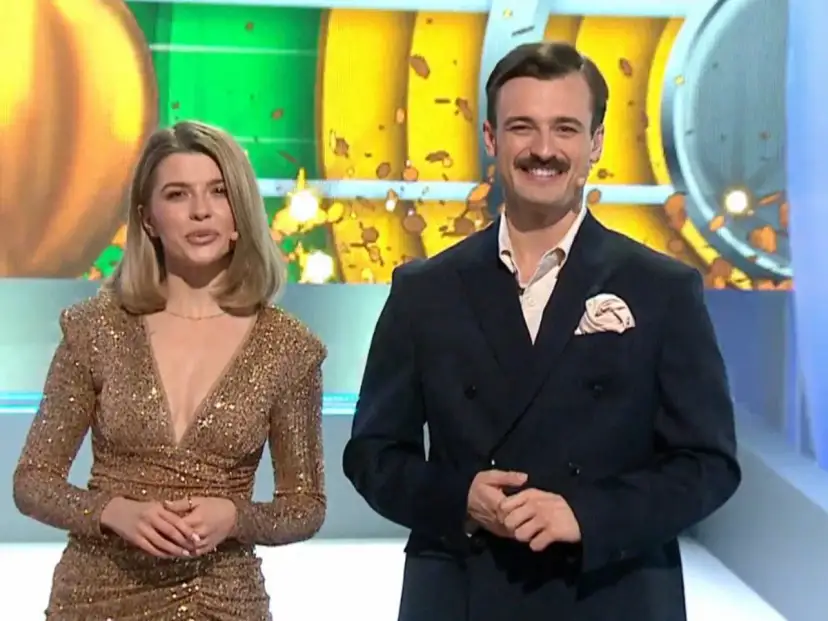 Para prowadzących w studio, ona w złotej sukni, on w garniturze. Czy to złota karta koło fortuny co to znaczy?