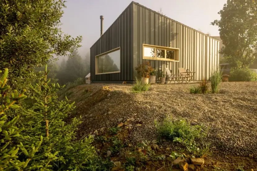 Nowoczesny dom szkieletowy na wzgórzu, otoczony zielenią. Zapytanie "ile wytrzyma dom szkieletowy" nabiera tu sensu, gdy patrzymy na jego solidną konstrukcję.