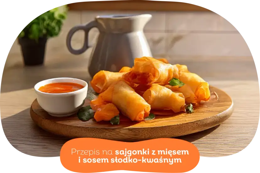 Chrupiące wege sajgonki z warzywami i sosem słodko-kwaśnym na drewnianej desce. Idealne na przekąskę.