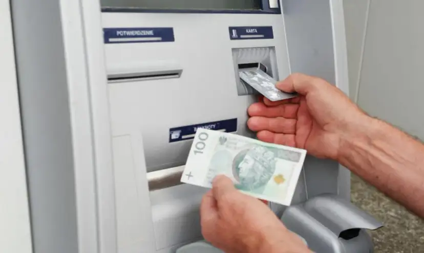 Wpłatomat przyjmuje banknoty, w tym 100 zł. Widać też wkładanie karty.