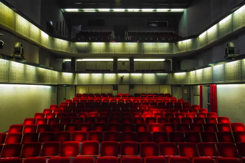 Puste czerwone fotele w teatrze Bagatela, widok na lożę i balkon.