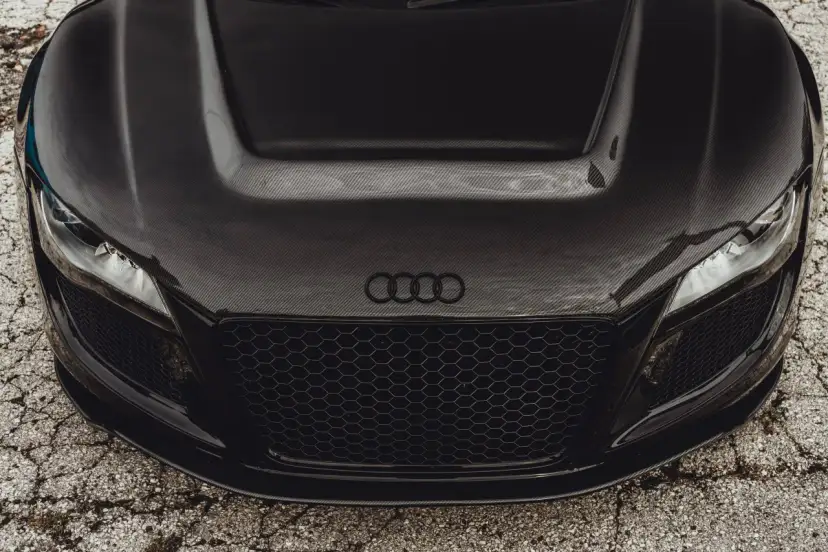 Maskownica i maska z włókna węglowego na czarnym aucie sportowym Audi.