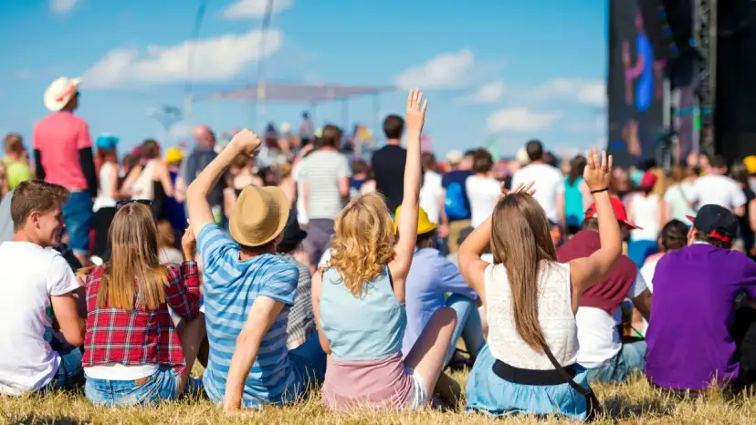 Widok zza pleców na tłum ludzi na jednym z największych festiwali muzycznych w Polsce. Słońce, niebo i dobra zabawa.