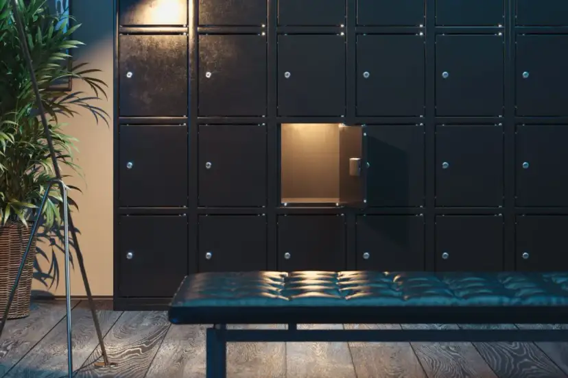 Rząd czarnych szafek, jedna otwarta, oświetlona od środka. Obok ławka i roślina. Kto to deponent?