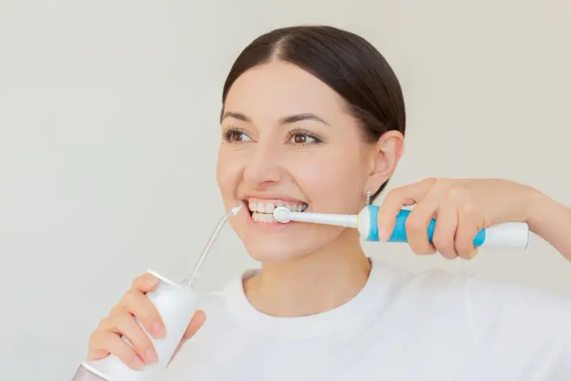 Kobieta używa irygatora do zębów, by zapewnić sobie idealną higienę jamy ustnej.