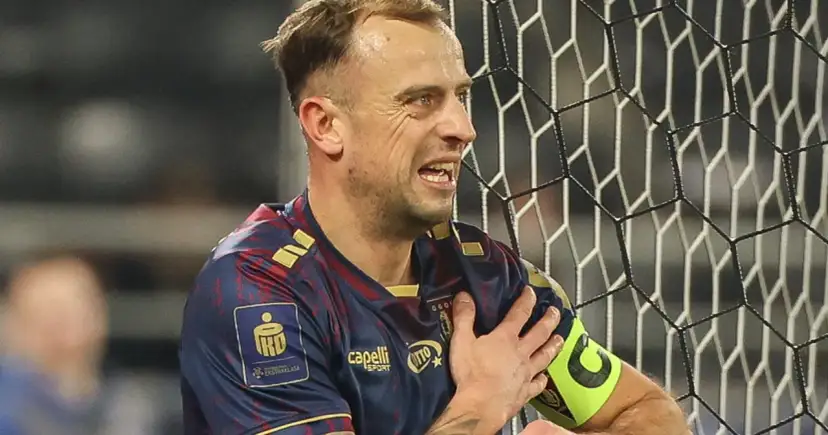 Piłkarz Pogoni Szczecin z opaską kapitana, zaciśniętą pięścią na ramieniu, w geście frustracji. Czy to odzwierciedla jego zarobki?