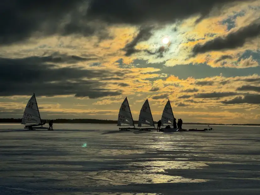 Lodowe żaglówki na zamarzniętym jeziorze o zachodzie słońca. Czy warto jechać do Dąbków na takie widoki? Tak!
