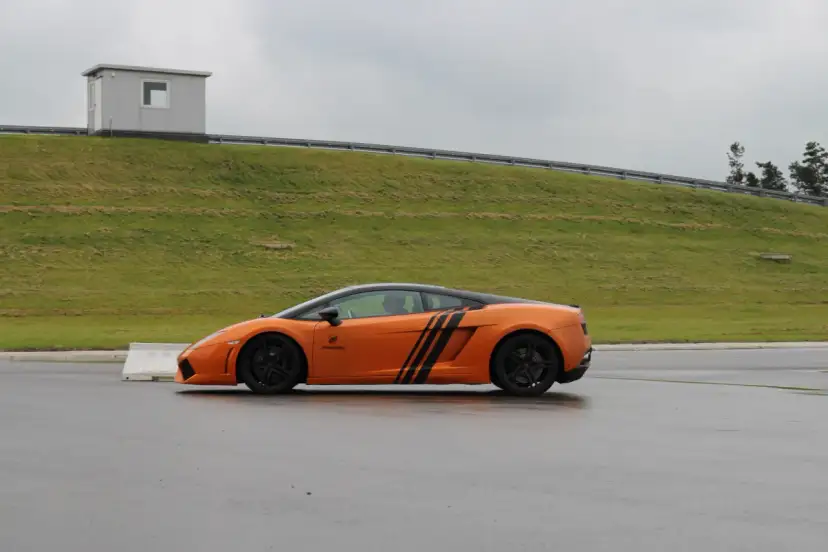 Pomarańczowe Lamborghini na torze. Zastanawiasz się, ile kosztuje przejazd takim autem?