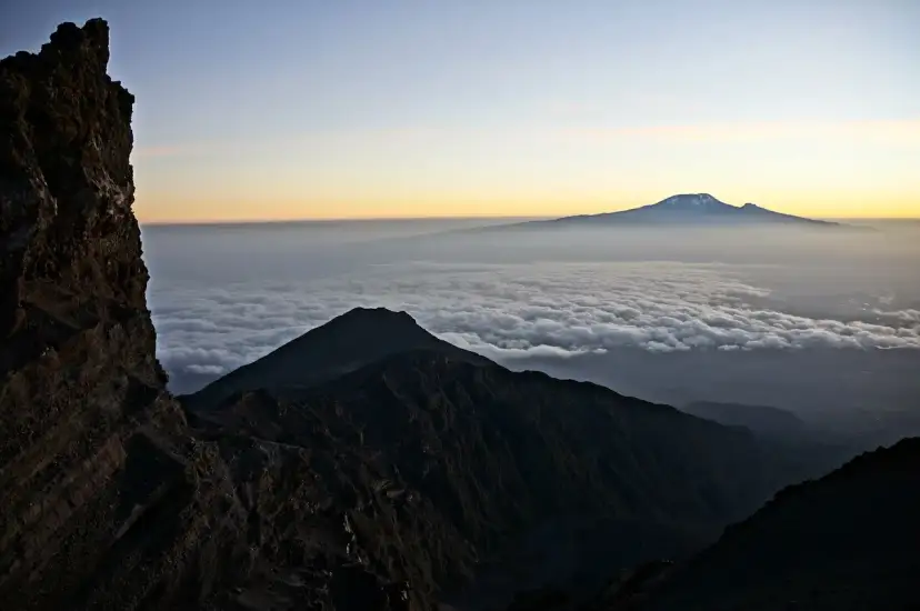 Widok z góry na morze chmur, z górującym w oddali majestatycznym Mount Meru.