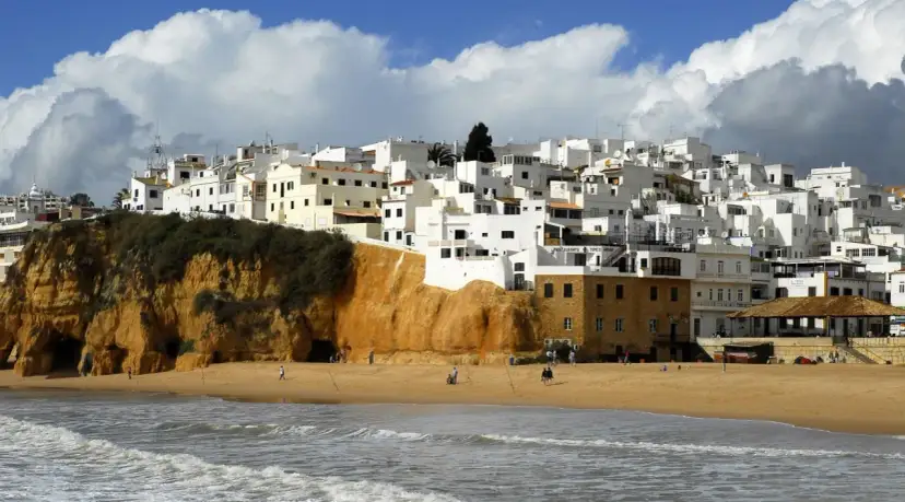 Białe domy na klifie, plaża i morze. Portugalia pogoda roczna, idealna na spacer.