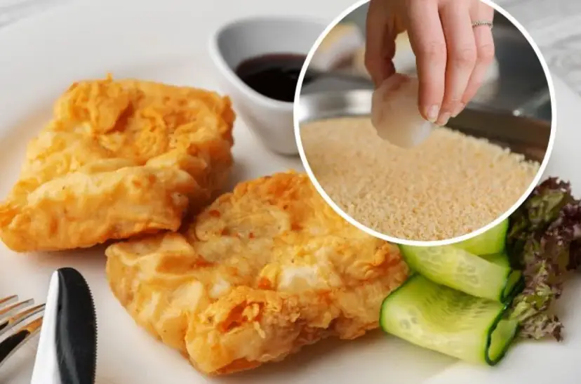 Złociste, panierowane kawałki ryby z ogórkiem i sałatką, w tle ręka obtaczająca rybę w bułce tartej.