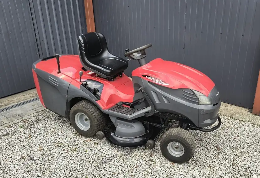 Czerwono-szary kosiarka traktorek używany Castelgarden, gotowy do pracy w ogrodzie.