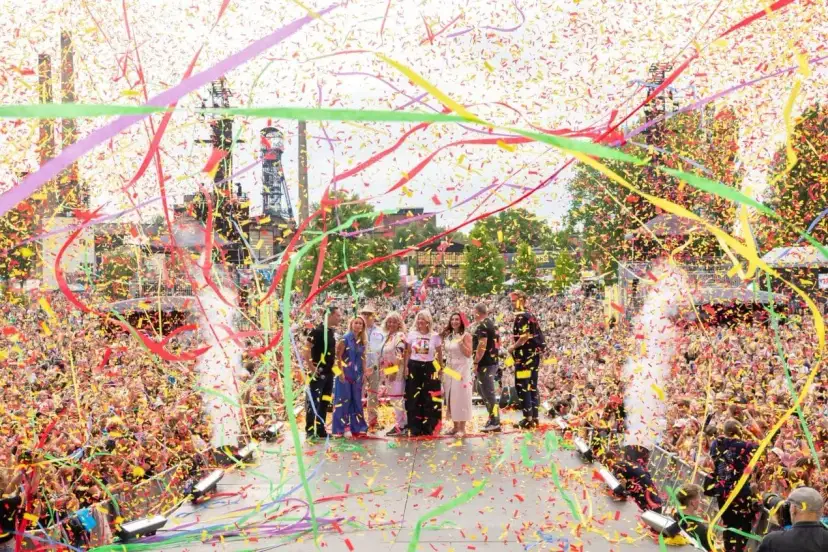 Tłum wiwatuje, a konfetti w żywych barwach, symbolizujące kolory Ostrawy, spada na scenę, gdzie stoi grupa ludzi.