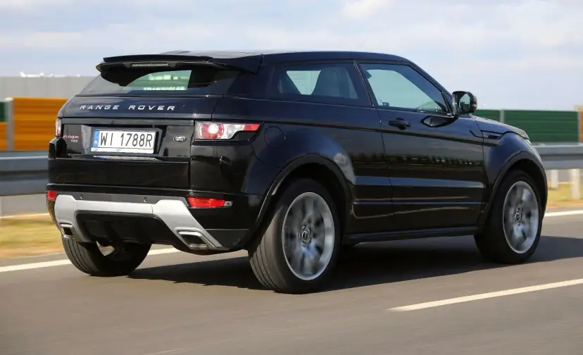 Czarny Land Rover Evoque jedzie po drodze, widać jego tylną część i obręcz koła w ruchu.
