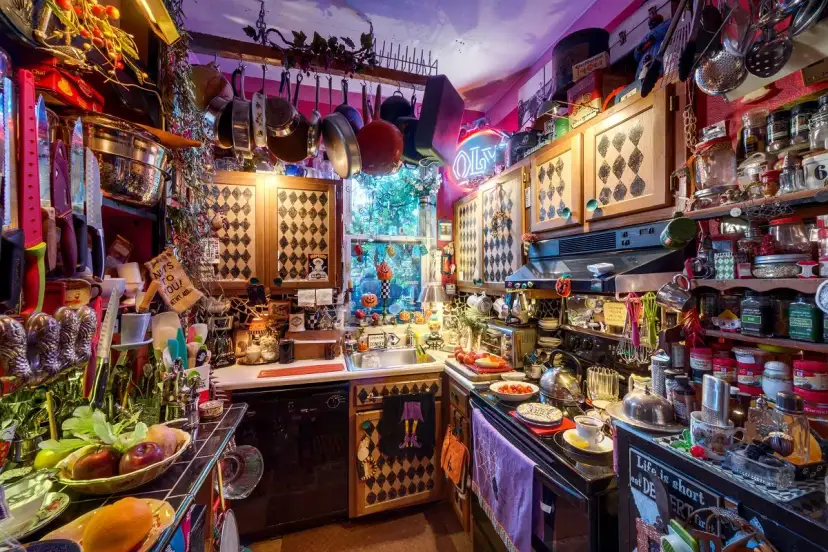 Kuchnia pełna przedmiotów, gdzie sztuka wyrzucania rzeczy jest wyzwaniem. Wiszące garnki, półki uginające się od słoików i dekoracji.