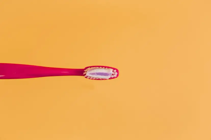 Różowa szczoteczka z pastą do zębów, zawierającą fluorek sodu, gotowa do walki z próchnicą. Fluor to klucz do zdrowych zębów.
