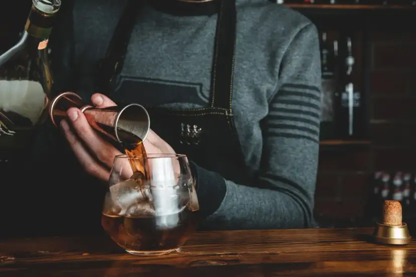Barman nalewa whisky Glenlivet 12 do szklanki z lodem. Wiele pozytywnych opinii potwierdza jej jakość.
