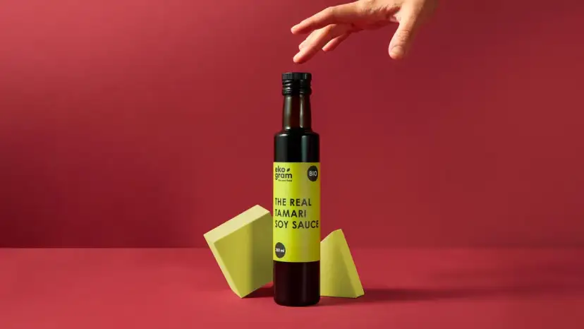 Butelka sosu tamari z etykietą "THE REAL TAMARI SOY SAUCE" na tle.